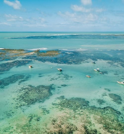 Stunning aerial shot of boats in the clear turquoise waters off Maceió, Brazil.